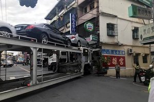 運載汽車的聯結車走錯路 卡在高雄市區動彈不得