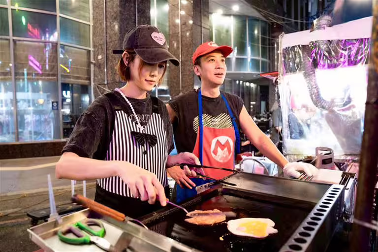 吳懷中與老婆小龜(左)一起擺攤賣三明治(圖/記者趙于瑩攝) 吳懷中與老婆小龜(左)一起擺攤賣三明治(圖/記者趙于瑩攝)